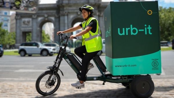 Courier rides an electric cargo bike with a large urb-it delivery box